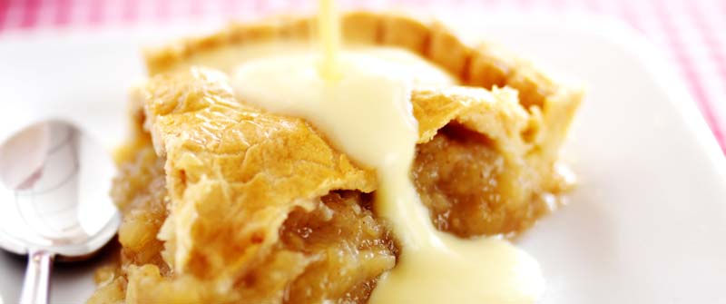 Vaniljsås som hälls över äppelpaj